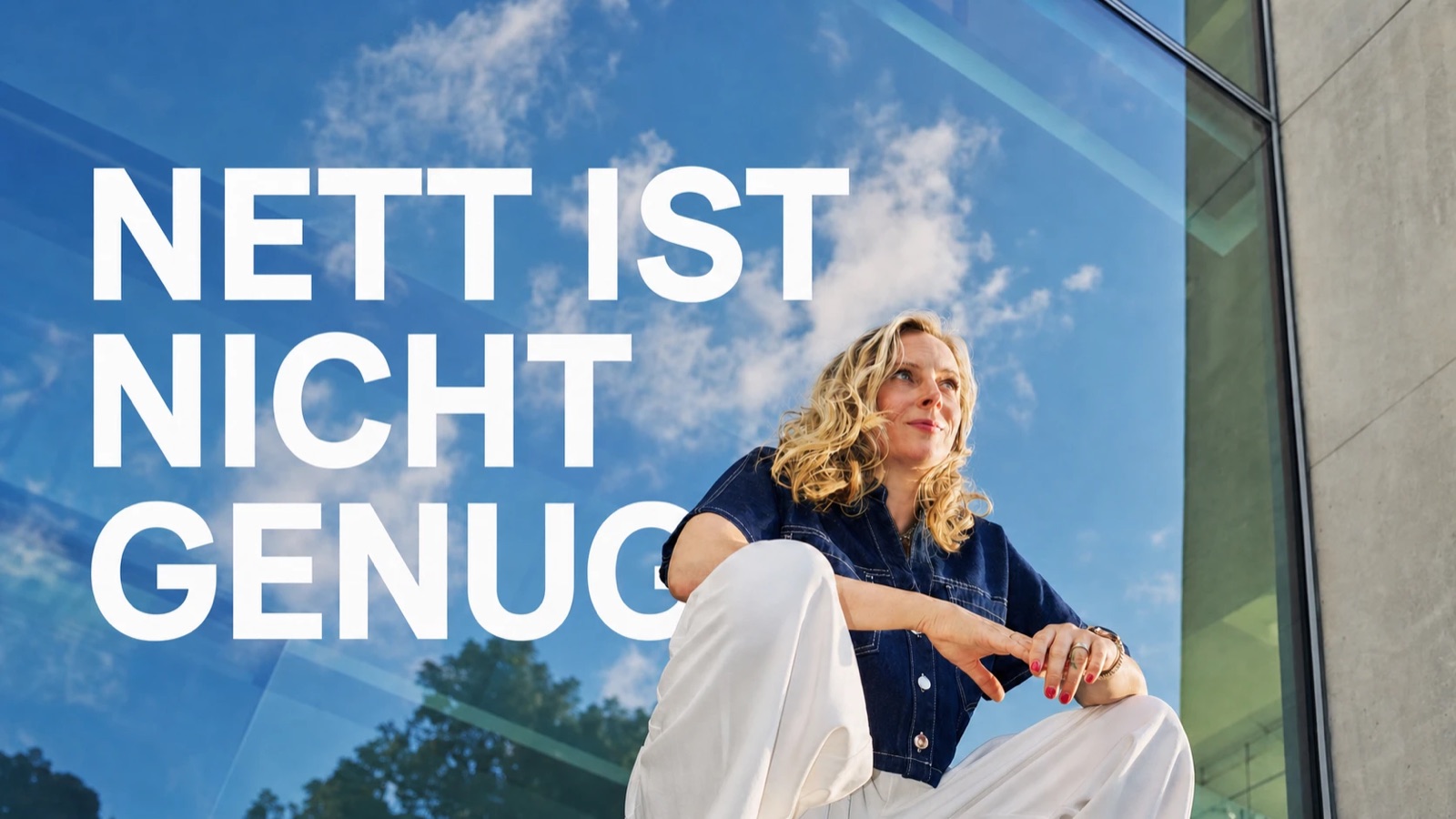 Hannah Dahl hockt vor einer Glasfassade mit blauem Himmel, davor der Text "Nett ist nicht genug"