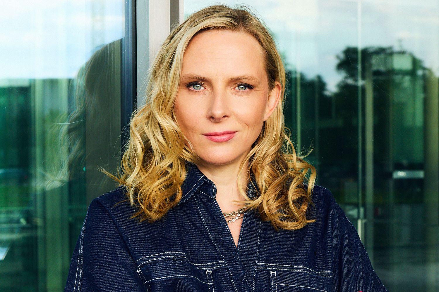Hannah Dahl mit verschränkten Armen vor einer Glasfassade