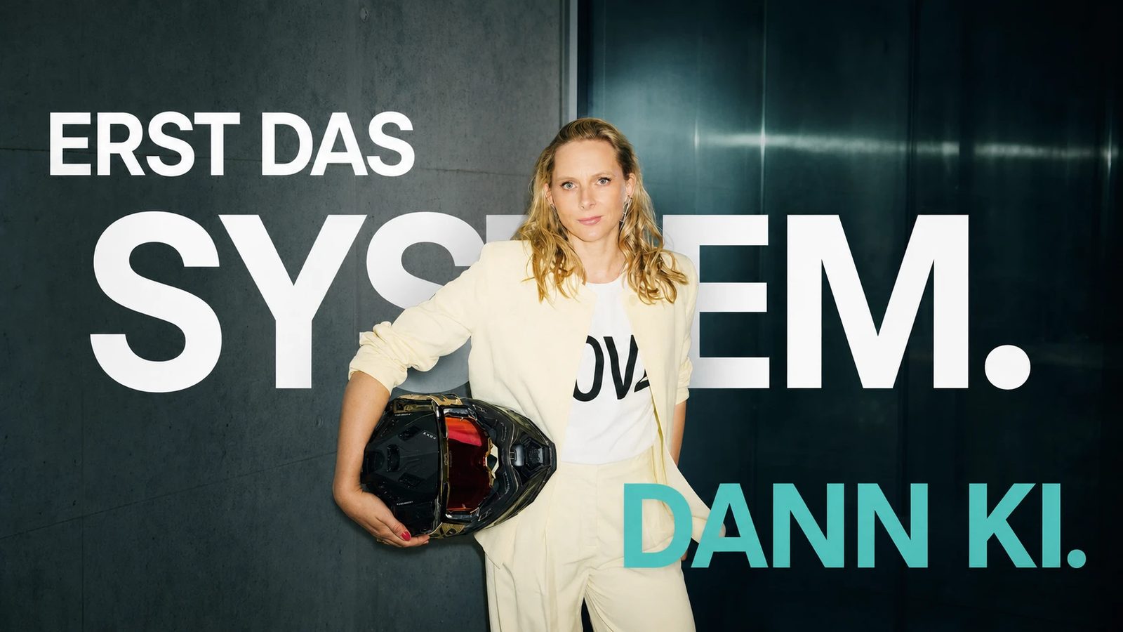 Hannah Dahl mit Motorradhelm unter dem Arm vor dem Schriftzug „Erst das System. Dann KI."