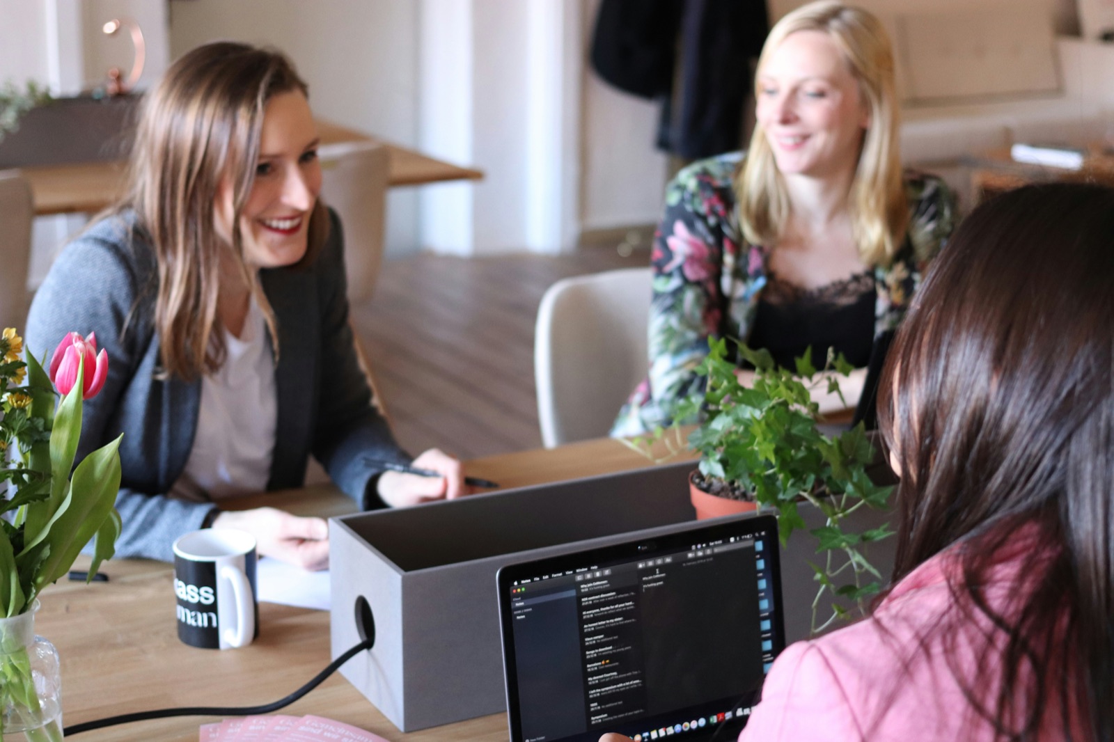 Drei Unternehmerinnen lachend in einer Runde — Women's AI Edge